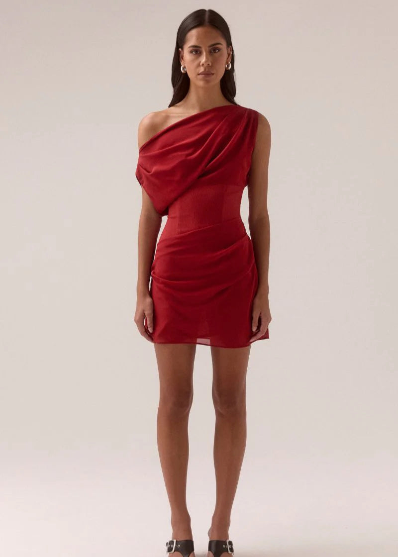 Woman wearing a red one-shoulder dress on a white background