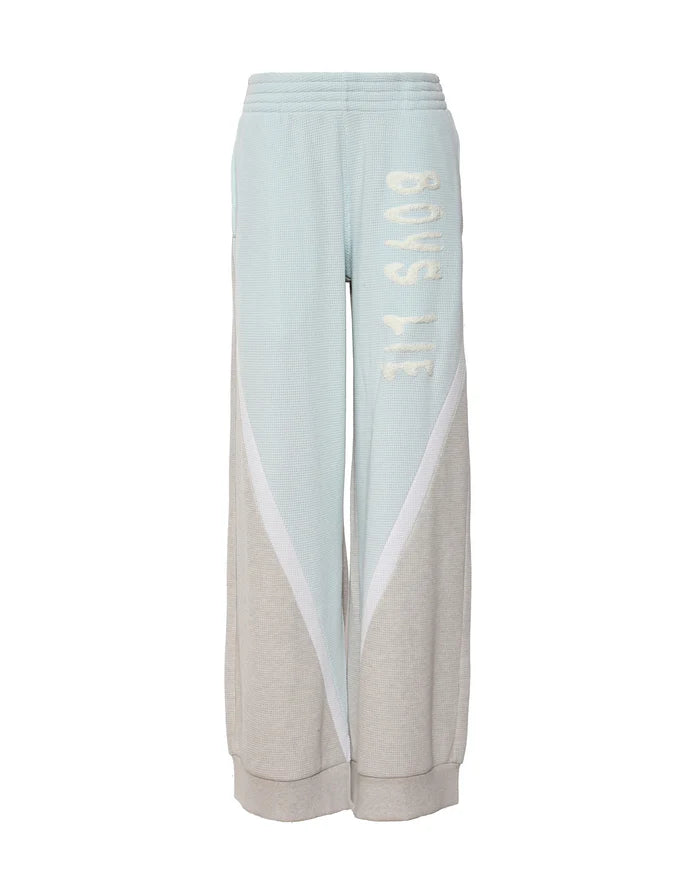 Two-tone pants with light blue and beige sections on a white background