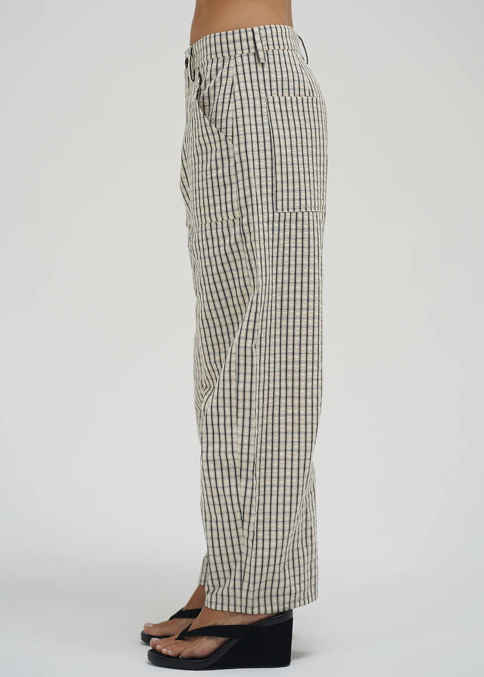 Checkered pants worn by a person on a white background
