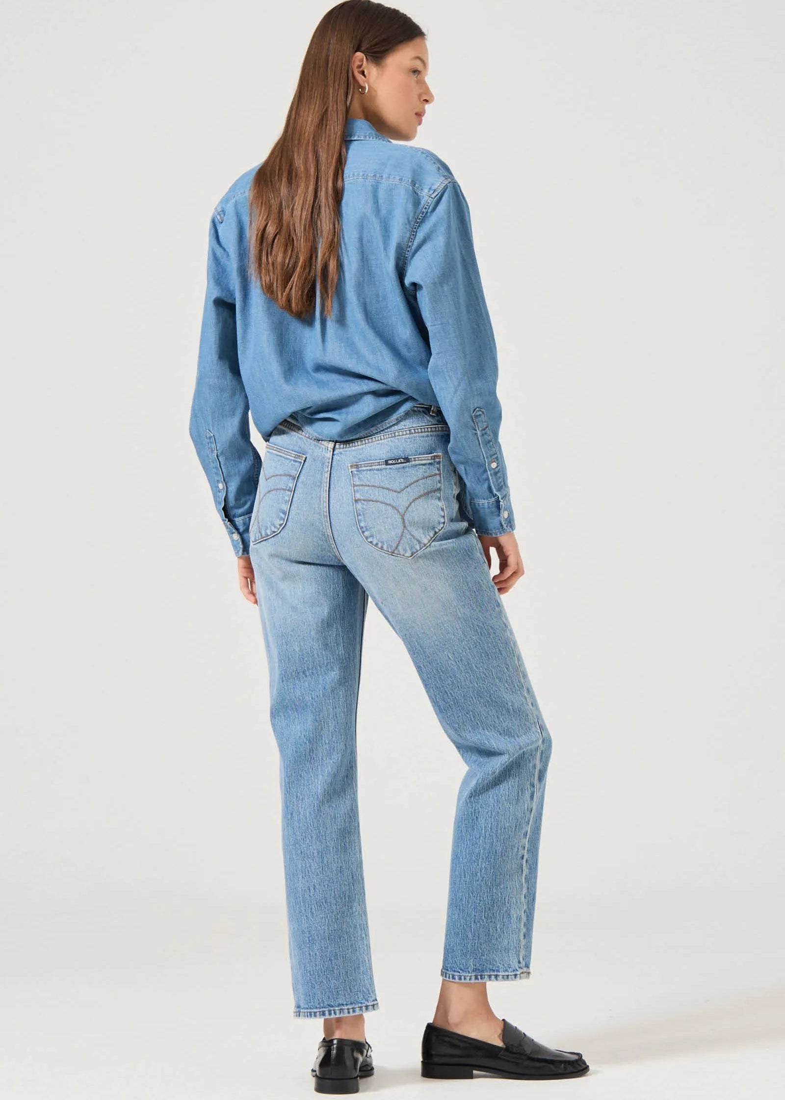 Person wearing a blue denim outfit on a white background