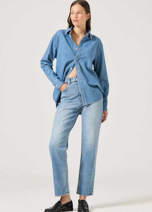 Woman wearing a blue denim shirt and jeans on a white background