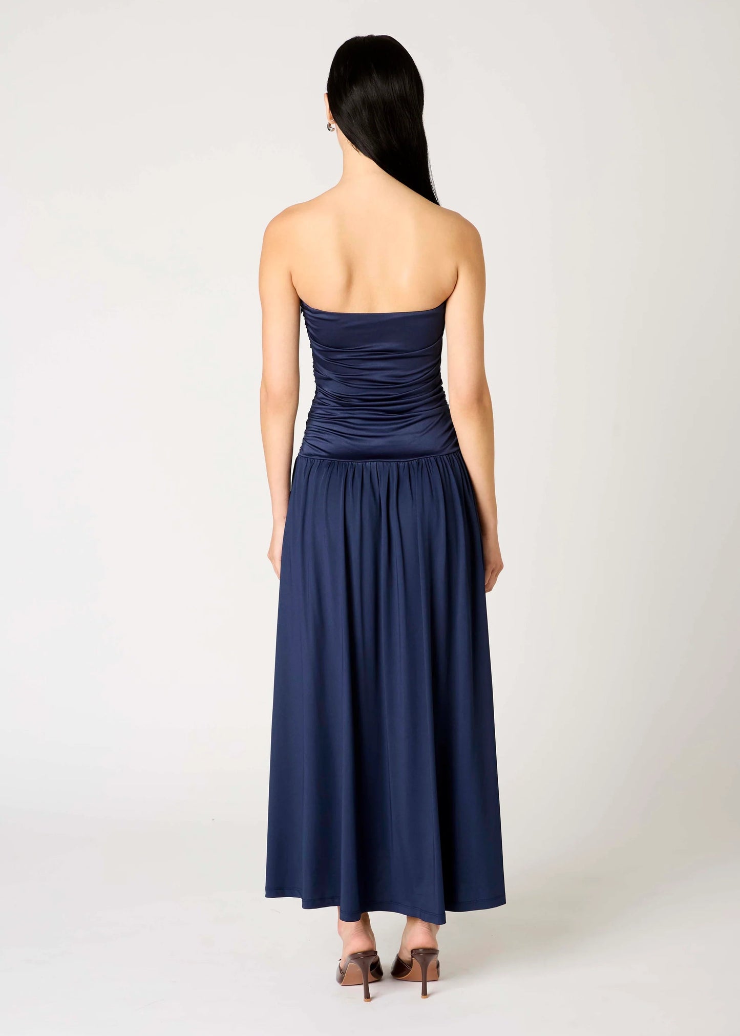 Navy strapless dress worn by a model on a white background