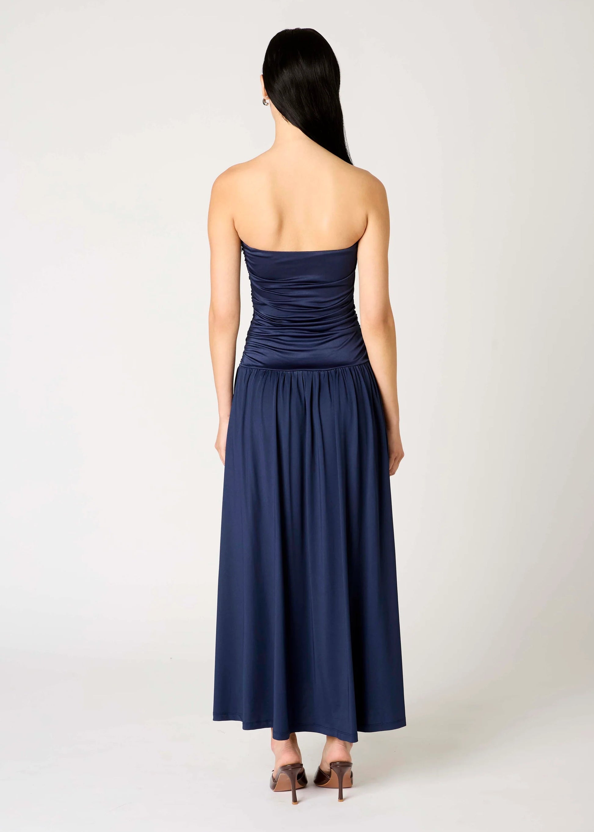 Navy strapless dress worn by a model on a white background
