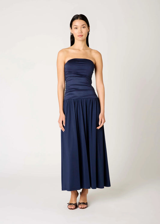 Woman wearing a strapless navy blue dress on a white background