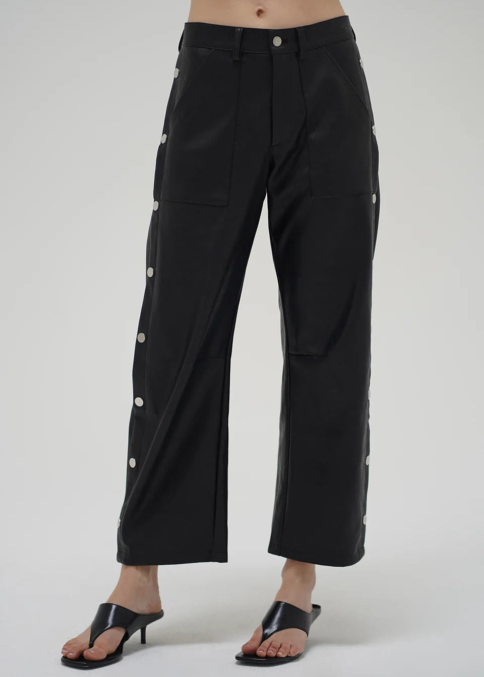 Black wide-leg pants with button details on a white background