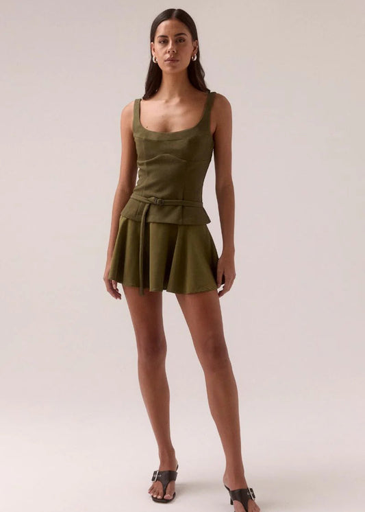 Woman wearing a green dress against a plain background