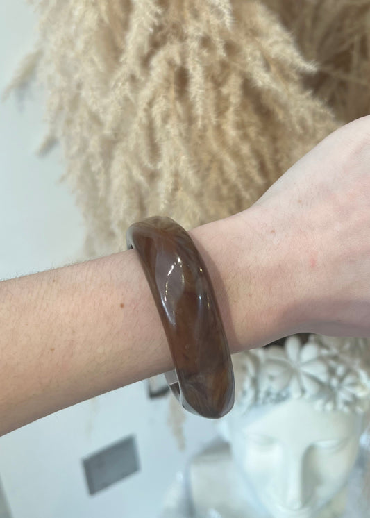 Brown bracelet on a wrist with a blurred background