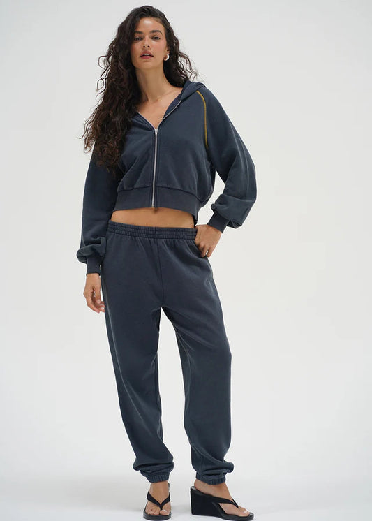 Woman wearing a dark gray tracksuit on a white background