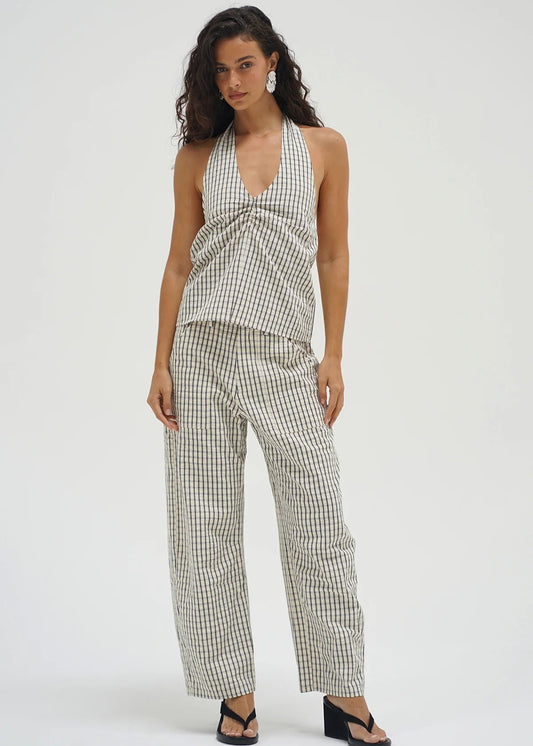 Woman wearing a checkered outfit on a white background. LNA clothing cross creek pant. White and cream barrel pant. 