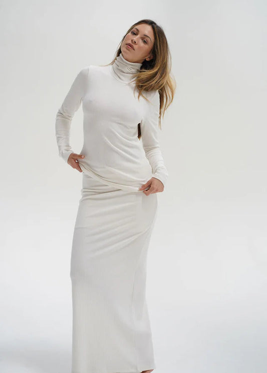 Woman wearing a long white dress against a white background