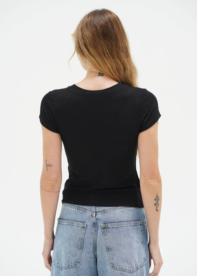 Person wearing a black t-shirt and blue jeans on a white background