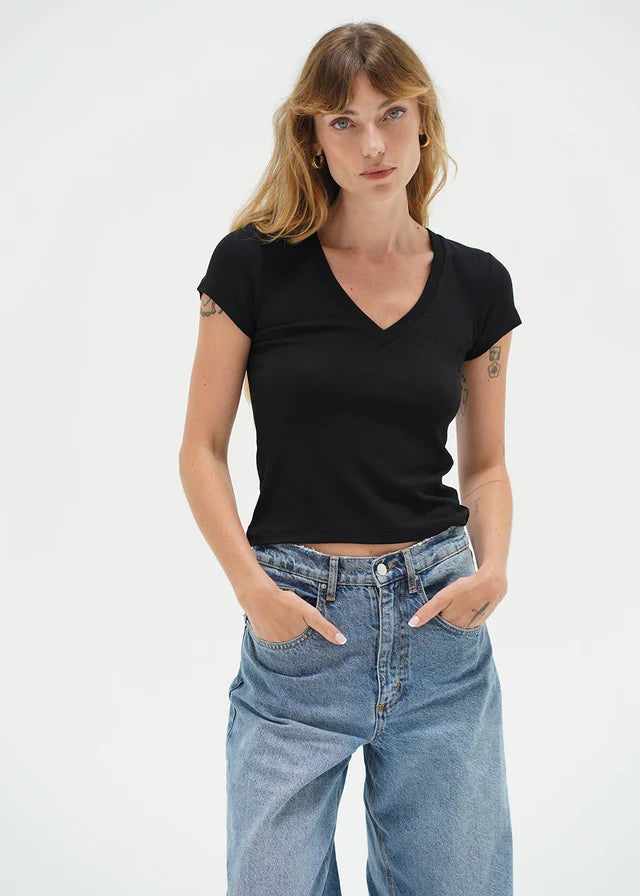 Woman wearing a black t-shirt and blue jeans on a white background