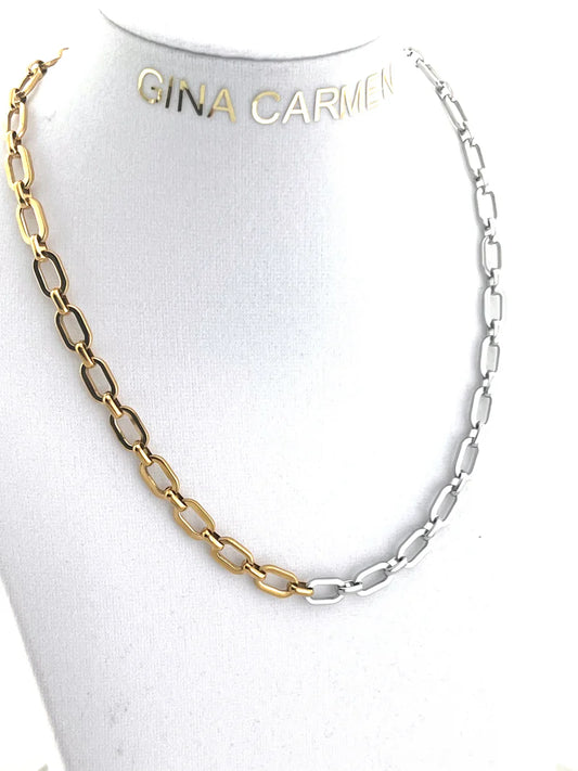 Two-tone gold and silver chain necklace on a mannequin with 'Gina Carmin' branding.