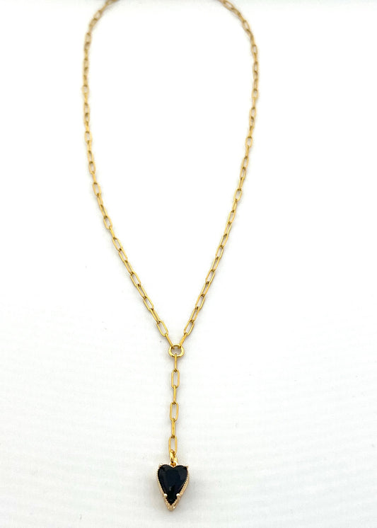 Gold necklace with a heart-shaped black pendant on a white background
