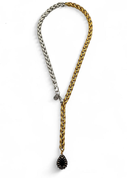 Two chain necklaces, one gold and one silver, with a black teardrop pendant on a white background.